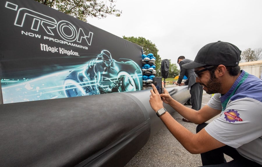 TRON attraction construction milestone at Magic Kingdom park - cast member signs name on first steel support columns for the new attraction