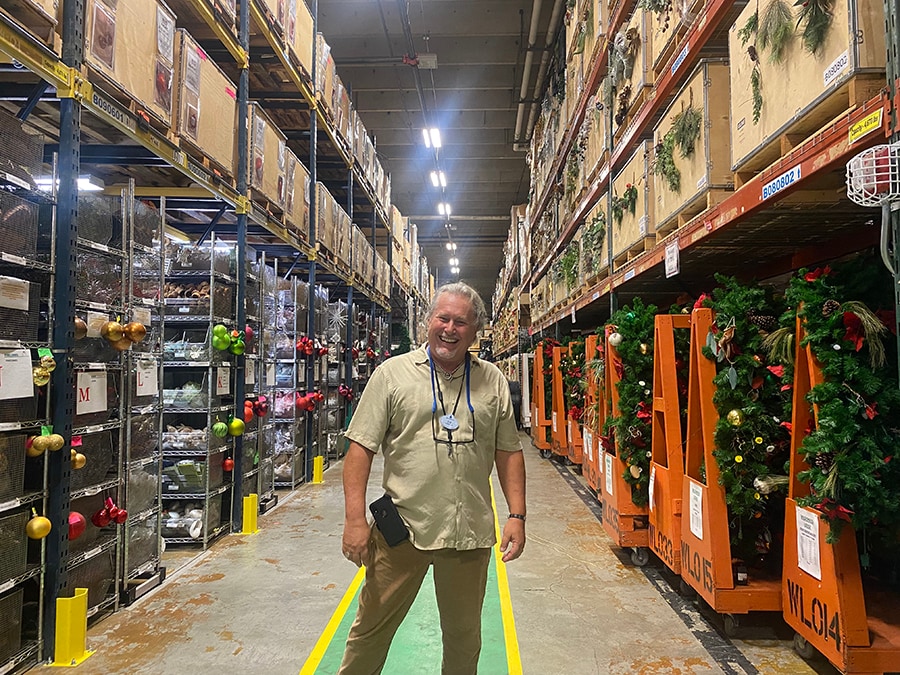 Ed smiles in an aisle at the Disney Holiday Services Warehouse