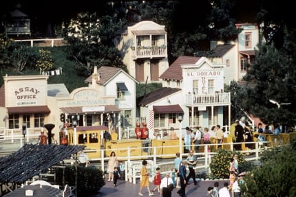 A mine train loads guests in front of the town of Rainbow Ridge.