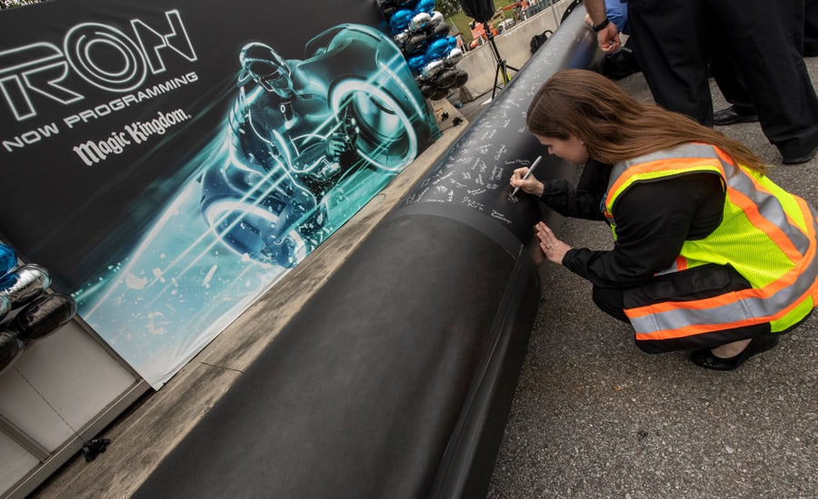 TRON attraction construction milestone at Magic Kingdom park cast member signs name on first steel support columns for the new attraction
