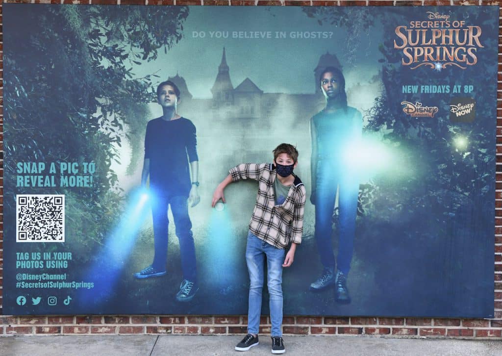 Preston Oliver from Disney’s ‘Secrets of Sulphur Springs’ at the photo wall at Disney Springs