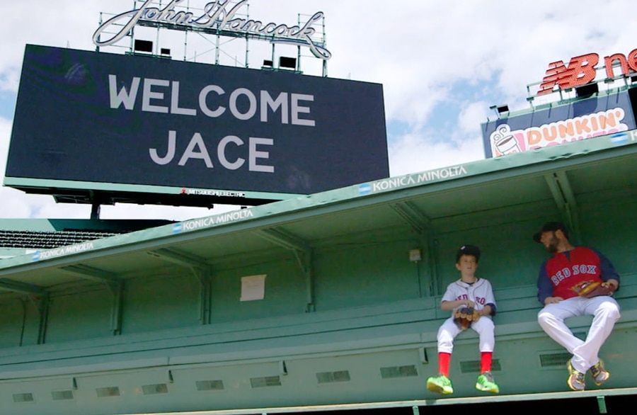 Make A Wish Kid Jace Andrews and Dustin Pedroia sit below "Welcome Jace" Sign at Fenway Park