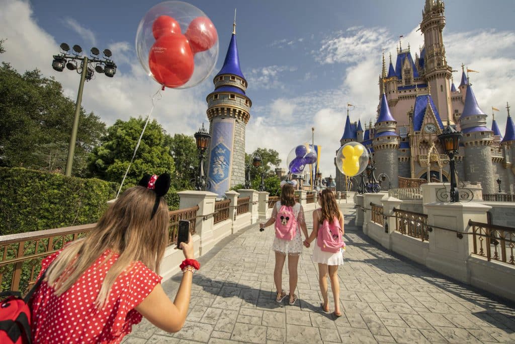 Family taking a picture in front of Cinderella Castle at Magic Kingdom Park