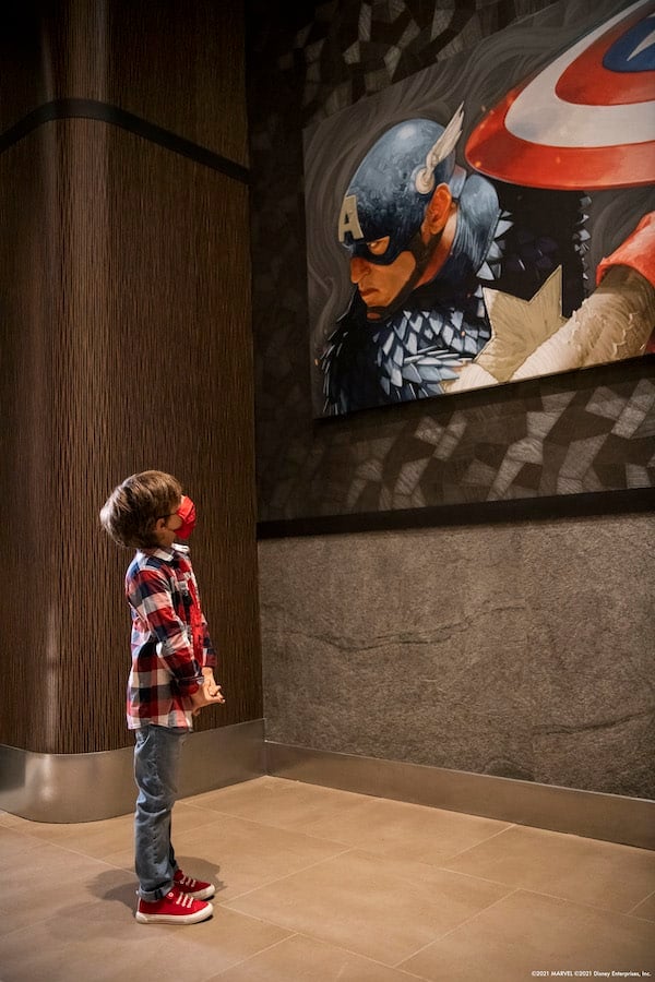 Boy looking at a portrait of Captain America in Disney’s Hotel New York –The Art of Marvel