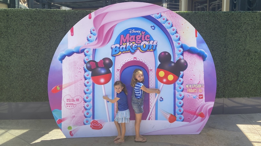 Girls with the "Disney’s Magic Bake-Off" photo wall at the Downtown Disney District