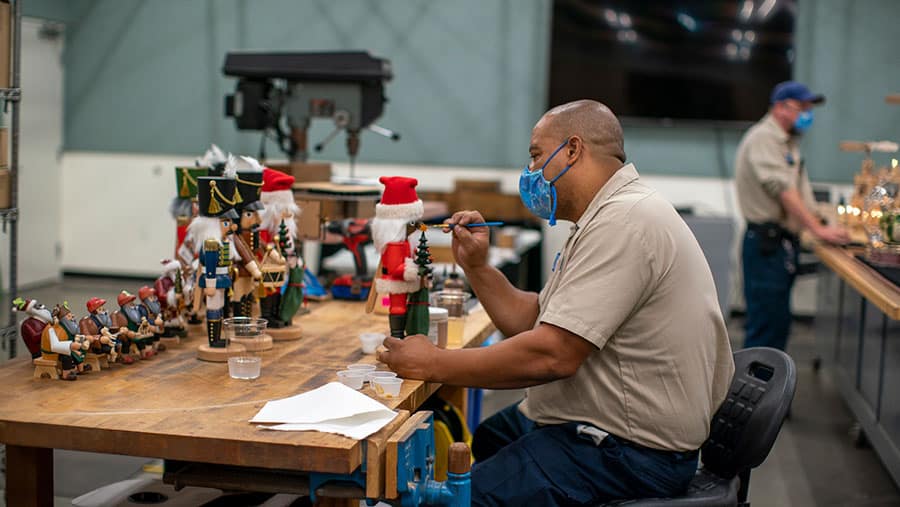 Cast member applying paiting details to nutcracker decoratoins