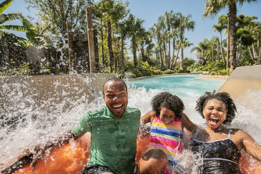 A family of three on a large inter tube on Miss Adventure Falls.