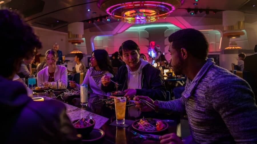 Passengers enjoy the Halcyon starcruiser dining experience in the Crown of Corella Dining Room in Star Wars Galactic Starcruiser at Walt Disney World Resort