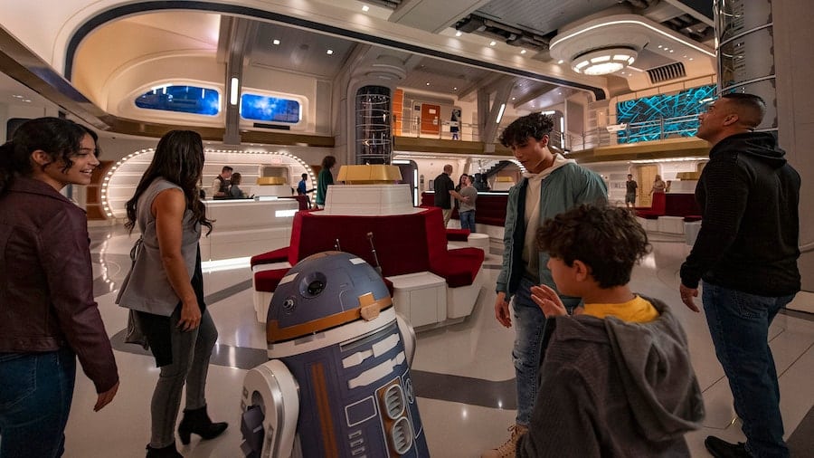 Astromech droid SK 62O greets guests in the Atrium of the Halcyon starcruiser in Star Wars Galactic Starcruiser at Walt Disney World Resort
