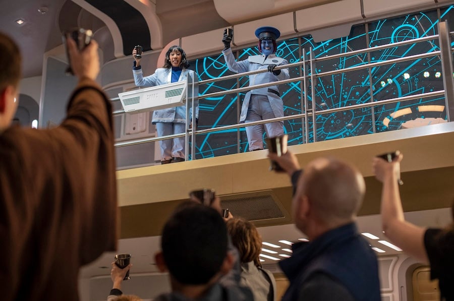 Cruise Director Lenka Mok left and Captain Riyola Keevan right share a toast with guests in Star Wars Galactic Starcruiser at Walt Disney World Resort