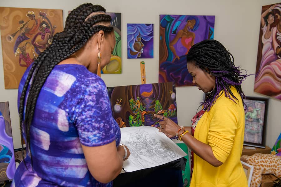 Charita Carter executive producer at Walt Disney Imagineering and New Orleans artist Sharika Mahdi looking at art together