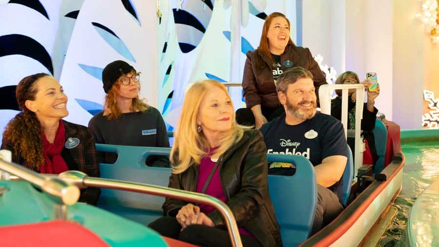 Cast members ride aboard an "it's a small world" boat