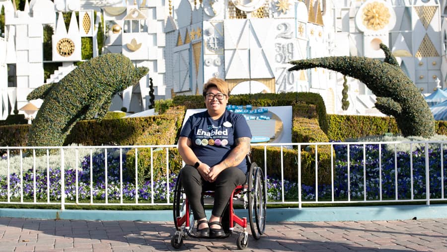 Guest Relations Hostess Sarah Nguyen in front of "it's a small world"