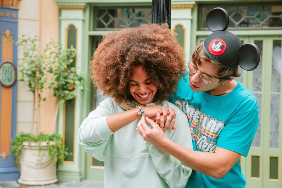 A couple admiring their Pandora Jewelry from Disney Parks