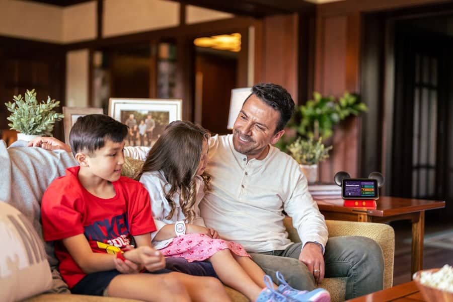a man and two kids sitting on a couch laughing