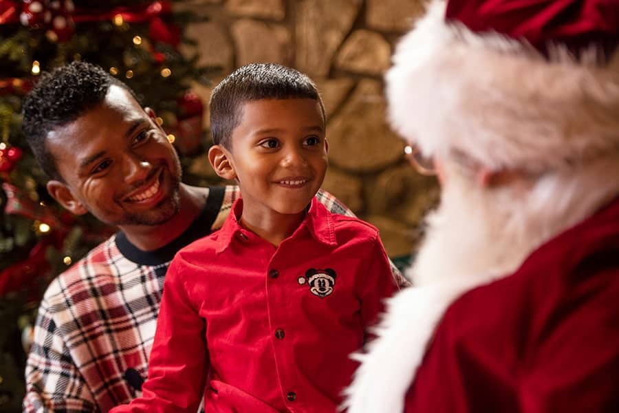 an adult and a child looking at santa claus