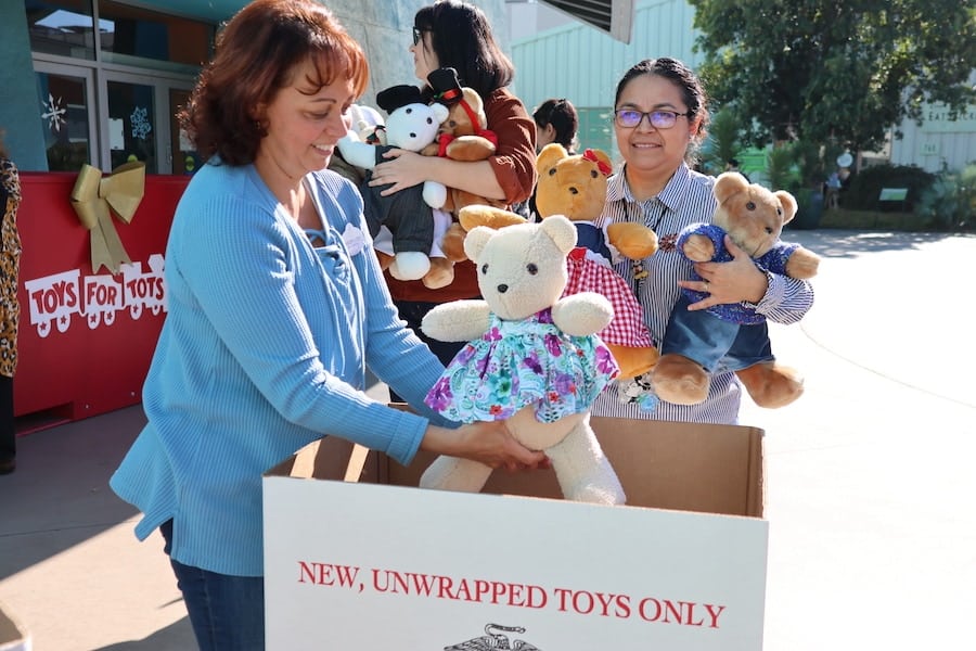 Disney Ultimate Toy Drive teddy bears pictured and Disney cast members volunteering