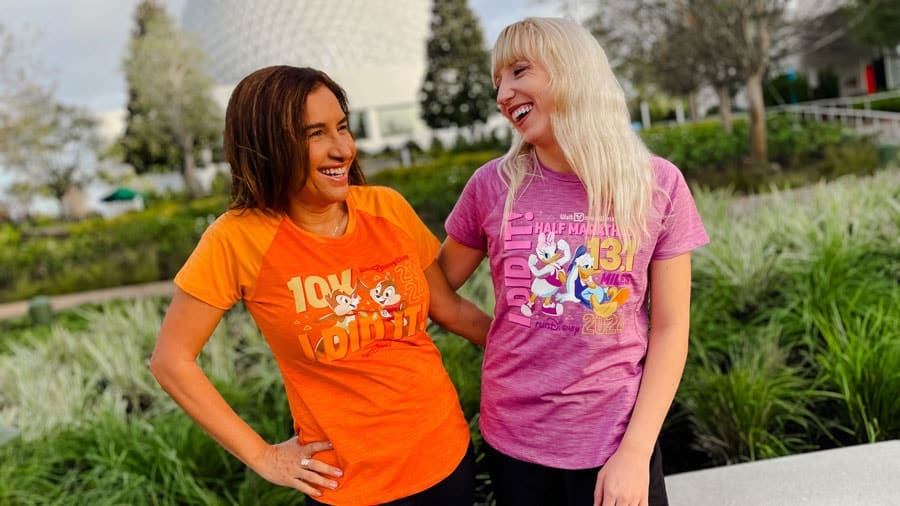 two ladies at Epcot laughing while wearing "half marathon I did it!" merch