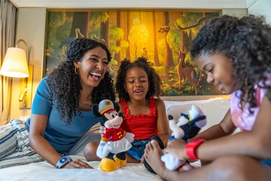 Family with Mickey Mouse and Minnie Mouse stuffed animals in a cabin on a Disney Cruise
