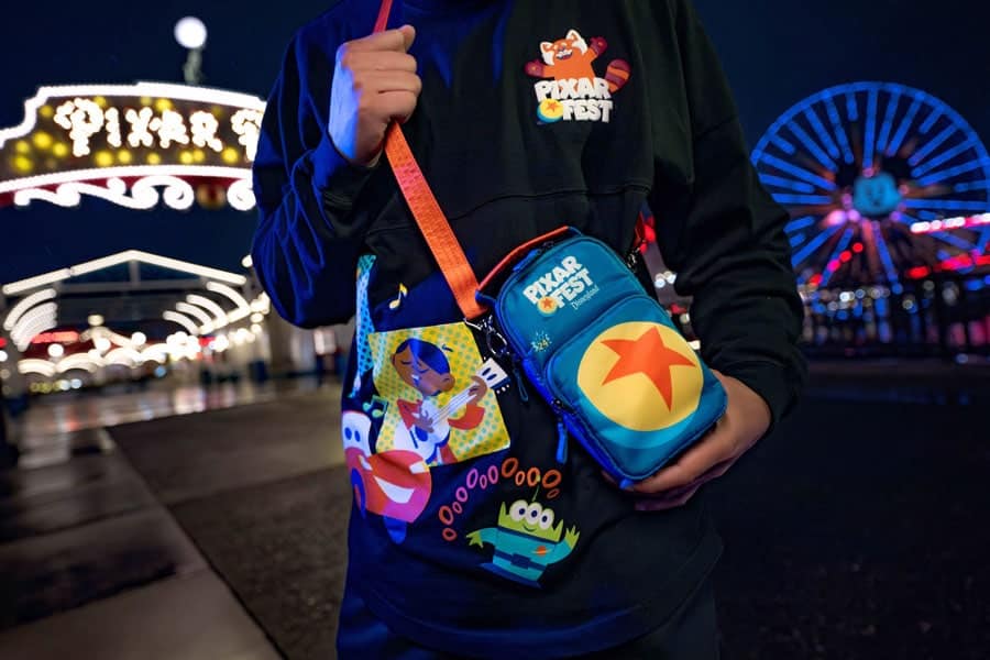 Person wearing the Pixar Fest Lug crossbody bag and spirit jersey at the Pixar Pier
