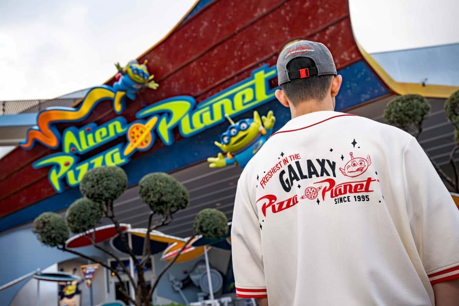 Person wearing a Pizza Planet T-shirt in front of Alien Pizza Planet