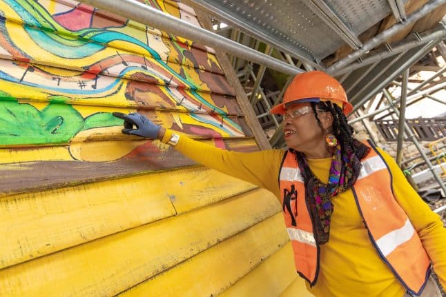 Malaika Favorite decorates the walls in the queue for Tiana's Bayou Adventure