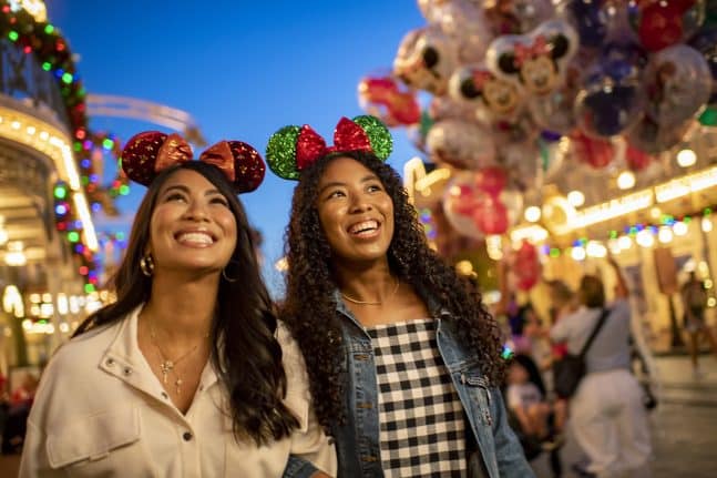 Guests smile on Main Street USA decorated for the holidays