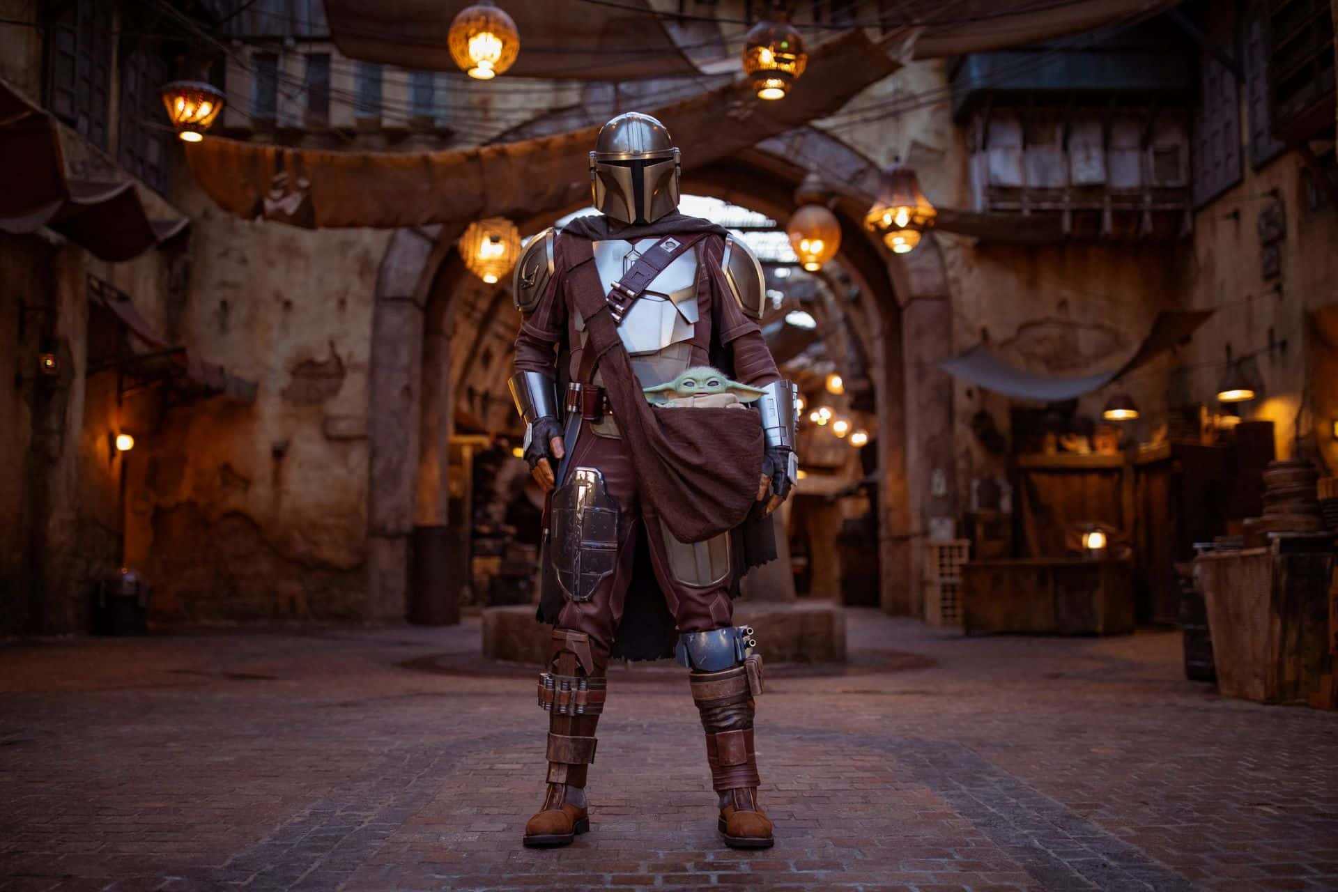 The mandalorian and grogu in star wars galaxys edge in disneyland park