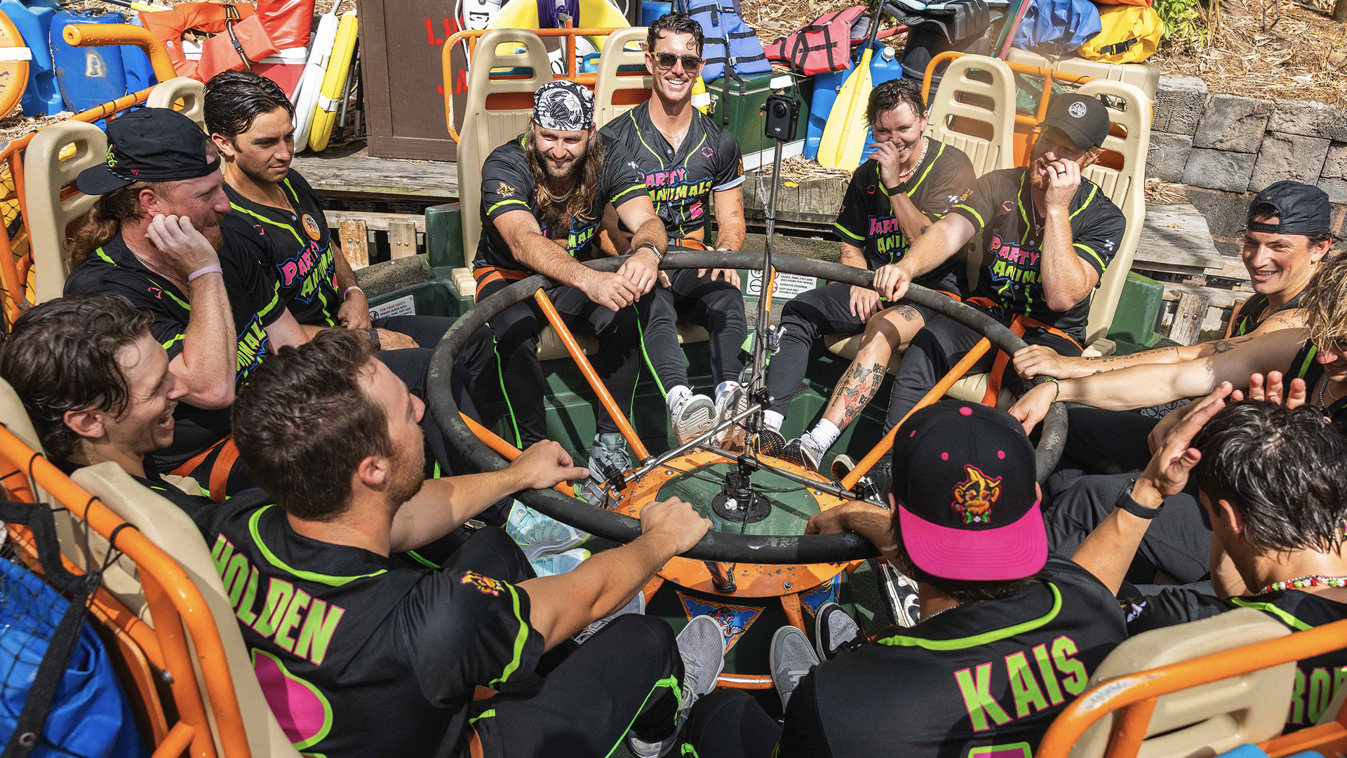 Banana Ball Makes Grand Slam Debut at Walt Disney World | The Main Street Mouse Group of Friends in Neon trimmed Black Shirts Around a Circular Steering Wheel on a Colorful Raft Smiling Together