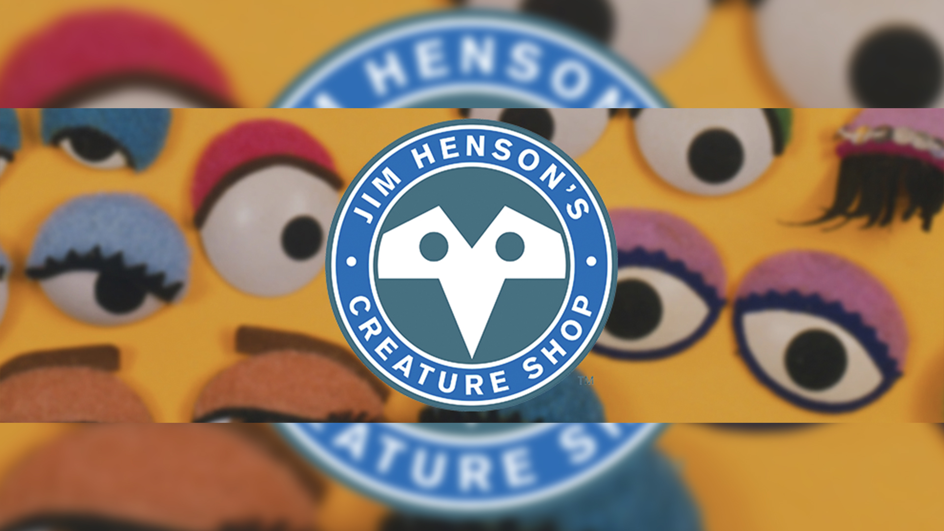 Jim Hensons Creature Shop | The Main Street Mouse Badge for Jim Henson's Creature Shop overlaying a blurred yellow Muppet background.